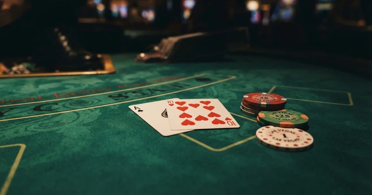 A close-up of a blackjack table felt with cards and chips laid out, no dealer or players visible.
